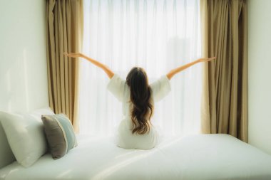 Genç Asyalı mutlu gülümseme. Yatak odasında rahatla.