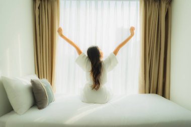 Genç Asyalı mutlu gülümseme. Yatak odasında rahatla.