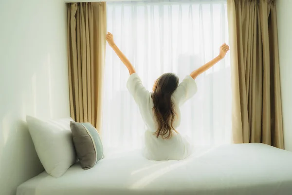 Giovane donna asiatica felice sorriso rilassarsi sul letto in camera da letto — Foto Stock
