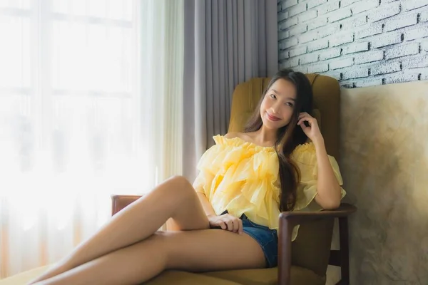 Retrato joven asiático mujer relajarse feliz sonrisa en sofá silla en li — Foto de Stock