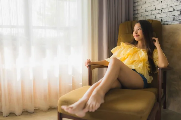 Retrato joven asiático mujer relajarse feliz sonrisa en sofá silla en li —  Fotos de Stock