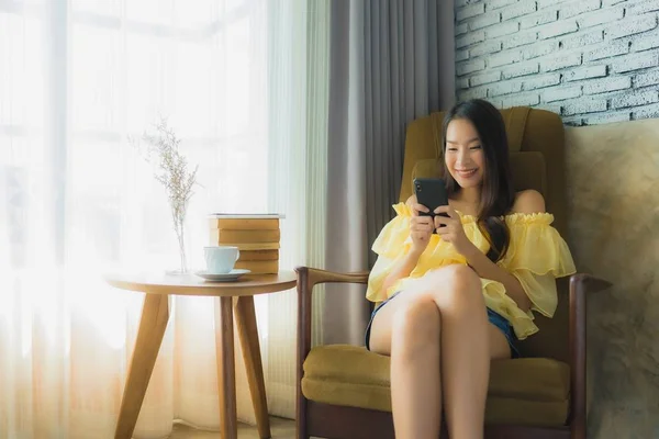 Porträt junge asiatische Frau mit Handy mit Kaffeetasse an — Stockfoto