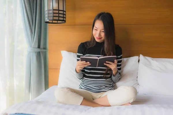 Porträt junge asiatische Frau liest Buch im Schlafzimmer — Stockfoto