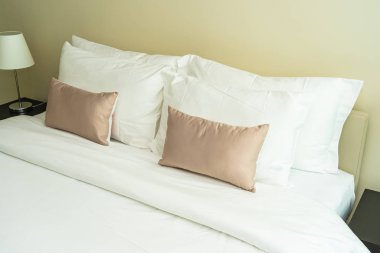 Yatak dekorasyonunda beyaz rahat yastık.