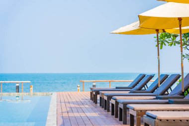 Dışarıda yüzme havuzu etrafında güzel boş bir sandalye şemsiyesi.
