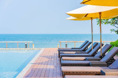 Dışarıda yüzme havuzu etrafında güzel boş bir sandalye şemsiyesi.