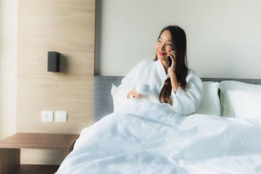 Güzel Asyalı genç kadınların portresi Kahveyle mutlu bir gülümseme ve