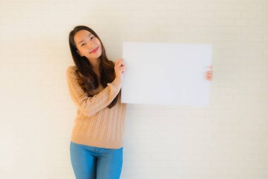 Güzel Asyalı genç kadınların portresi boş beyaz kağıt yaban domuzu gösteriyor.