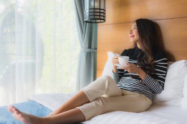 Yataktaki genç Asyalı kadının portresi. İçi kahveyle dolu.