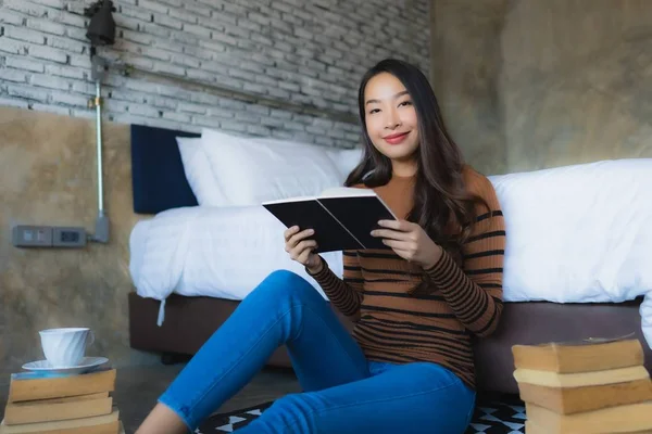 Joven mujer asiática con taza de café y leer libro — Foto de Stock