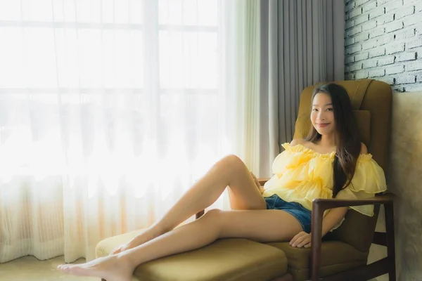 Ritratto giovane donna asiatica relax felice sorriso su divano sedia in li — Foto Stock