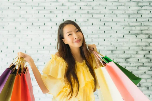 Portrét mladá asijská žena drží barevné nákupní taška — Stock fotografie