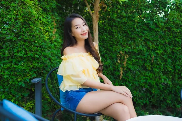 Fiatal ázsiai nő boldog mosoly pihenjen és üljön le a székre — Stock Fotó