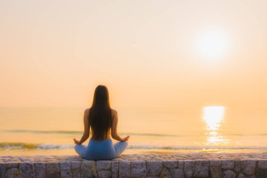 Genç Asyalı kadının portresi, deniz kıyısı okyanusunda meditasyon yapıyor. 