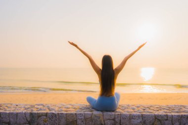 Genç Asyalı kadının portresi, deniz kıyısı okyanusunda meditasyon yapıyor. 