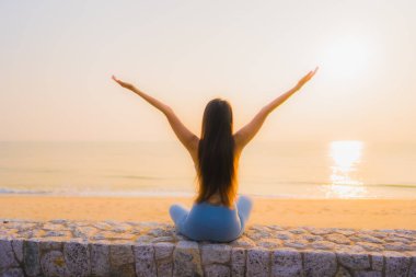 Genç Asyalı kadının portresi, deniz kıyısı okyanusunda meditasyon yapıyor. 