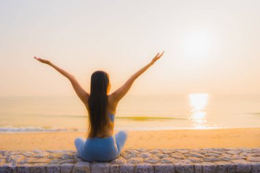 Genç Asyalı kadının portresi, deniz kıyısı okyanusunda meditasyon yapıyor. 