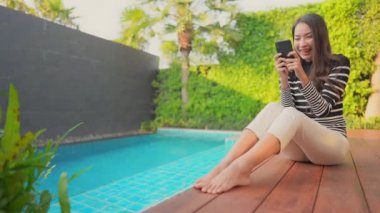 Güzel Asyalı bir kadının oteldeki havuzda dinlenirken çekilmiş görüntüleri.