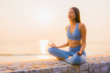 Genç Asyalı kadının portresi, deniz kıyısı okyanusunda meditasyon yapıyor. 