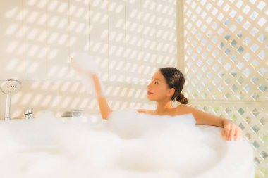 Portre genç Asyalı kadın rahatla küvette banyo yap.