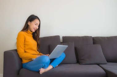 Dizüstü bilgisayarı kullanan Asyalı genç bir kadının portresi.