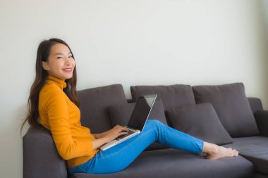 Dizüstü bilgisayarı kullanan Asyalı genç bir kadının portresi.