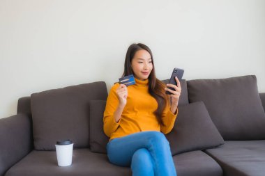 Genç Asyalı kadının akıllı mobili dizüstü bilgisayar kullanan portresi.