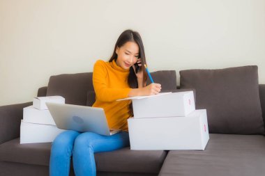 Genç Asyalı kadının portresi P ile çalışmak için dizüstü bilgisayar kullanıyor.