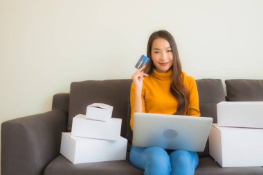 Genç Asyalı kadının portresi P ile çalışmak için dizüstü bilgisayar kullanıyor.