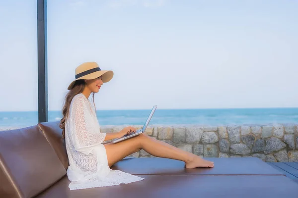 Retrato joven mujer asiática utilizando ordenador portátil alrededor de la playa se — Foto de Stock