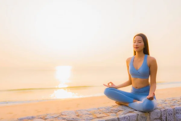 Porträtt ung asiatisk kvinna gör meditation runt havet strand — Stockfoto