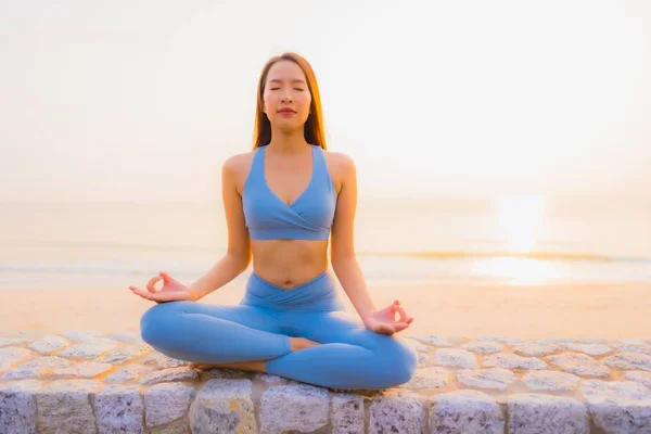 Porträtt ung asiatisk kvinna gör meditation runt havet strand — Stockfoto