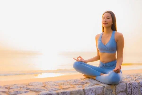 Porträtt ung asiatisk kvinna gör meditation runt havet strand — Stockfoto