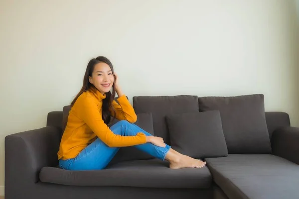 Portrait jeune asiatique femme heureux relax sourire sur canapé chaise avec — Photo