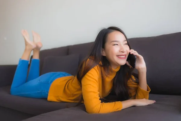 Portrait jeune femme asiatique en utilisant le téléphone mobile intelligent sur le canapé avec — Photo