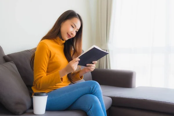 Ritratto giovane donna asiatica leggere libro su divano sedia con cuscino i — Foto Stock