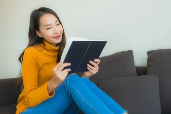 Retrato joven asiática mujer leer libro en sofá silla con almohada i — Foto de Stock