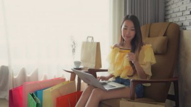 Evinden e-alışveriş yapan güzel Asyalı kadının görüntüleri.