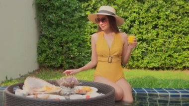 Güzel Asyalı bir kadının oteldeki havuzda dinlenirken çekilmiş görüntüleri.