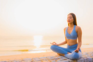 Genç Asyalı kadının portresi, deniz kıyısı okyanusunda meditasyon yapıyor. 