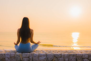 Genç Asyalı kadının portresi, deniz kıyısı okyanusunda meditasyon yapıyor. 