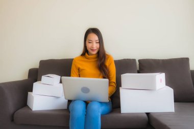 Genç Asyalı kadının portresi P ile çalışmak için dizüstü bilgisayar kullanıyor.