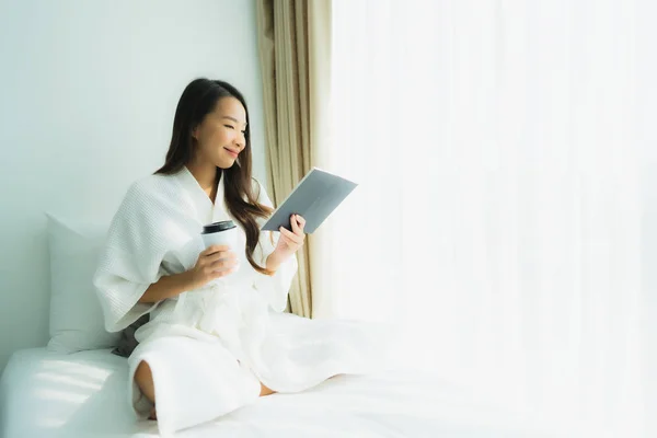 Junge asiatische Frau mit Kaffeetasse und Buch lesen — Stockfoto