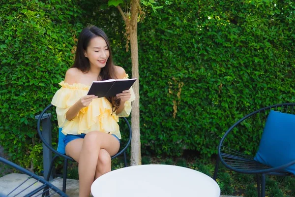 Joven mujer asiática leer libro alrededor al aire libre jardín naturaleza —  Fotos de Stock