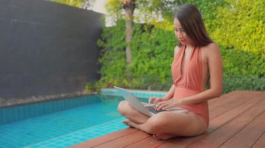 Güzel Asyalı bir kadının oteldeki havuzda dinlenirken çekilmiş görüntüleri.