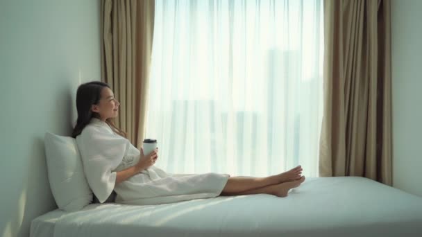 美しいアジア系女性が自宅でコーヒーを飲み — ストック動画