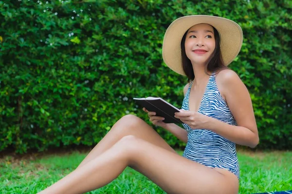 Portrait beautiful young asian woman read book around swimming p — Stock Photo, Image