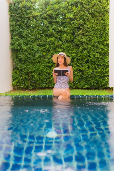 Portrait beautiful young asian woman read book around swimming p — 스톡 사진