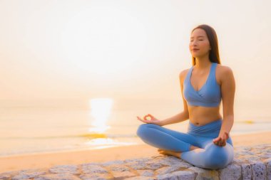 Genç Asyalı kadının portresi, deniz kıyısı okyanusunda meditasyon yapıyor. 