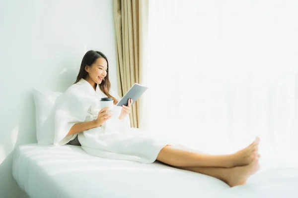 Junge asiatische Frau mit Kaffeetasse und Buch lesen — Stockfoto